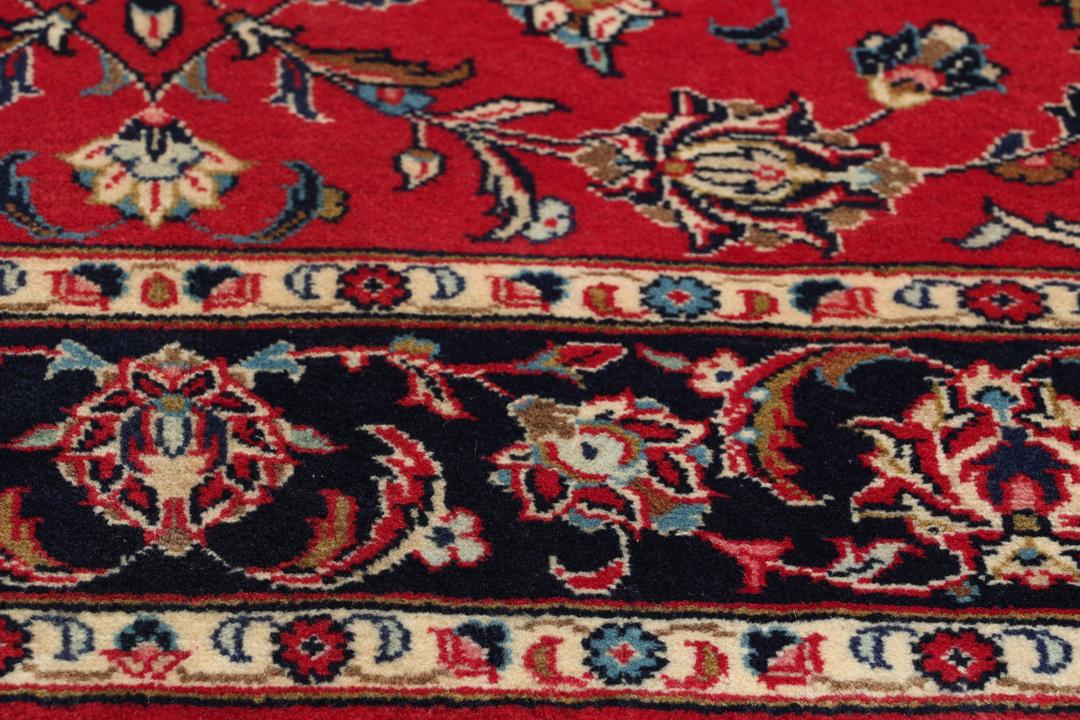 Hand-knotted Keshan rug from the Middle East featuring a vibrant red field with intricate floral patterns.