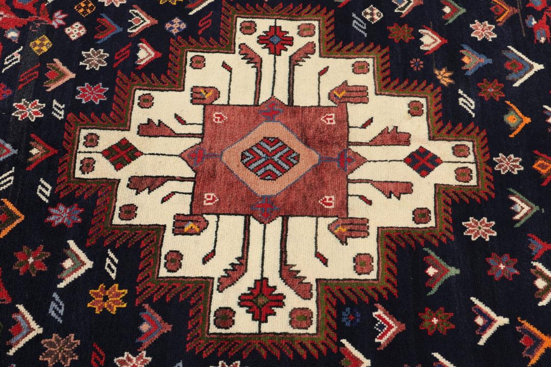 Hand-knotted Sirdjan rug from the Middle East with a dark-blue field and floral medallion pattern.