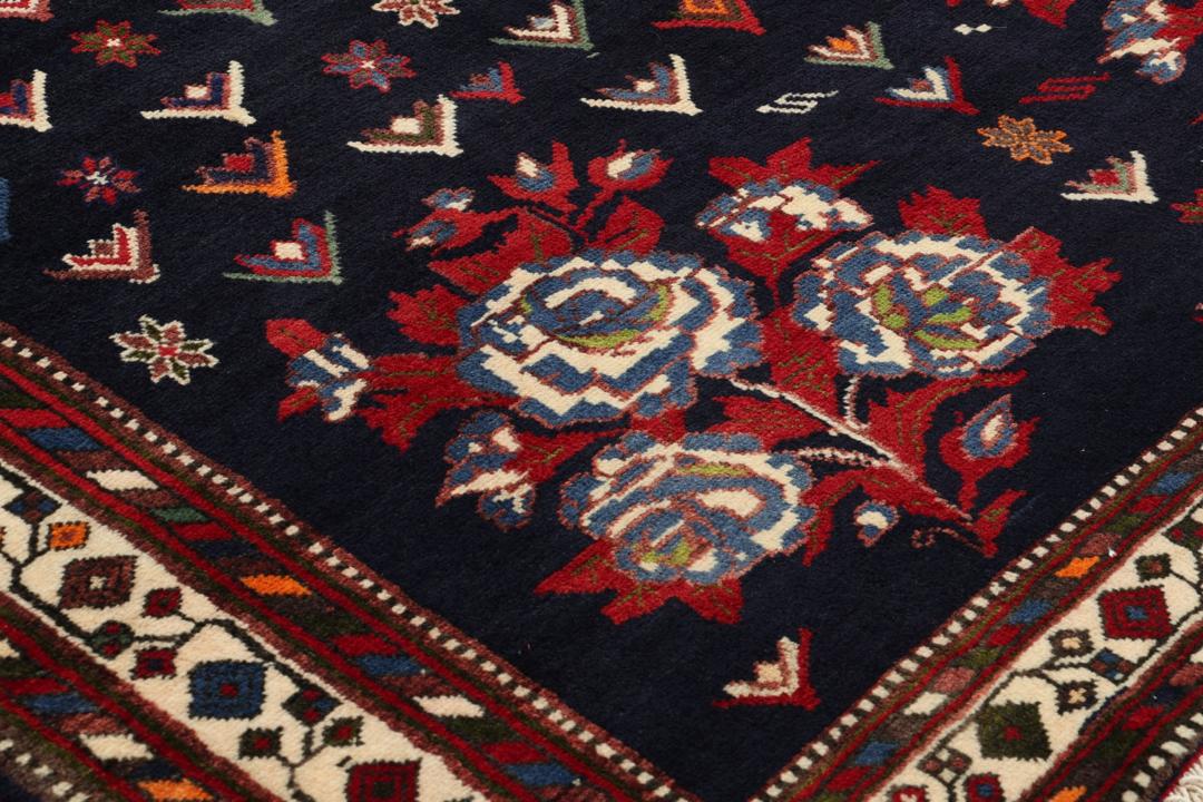 Hand-knotted Sirdjan rug from the Middle East with a dark-blue field and floral medallion pattern.