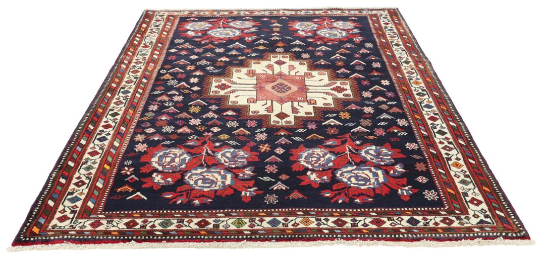 Hand-knotted Sirdjan rug from the Middle East with a dark-blue field and floral medallion pattern.