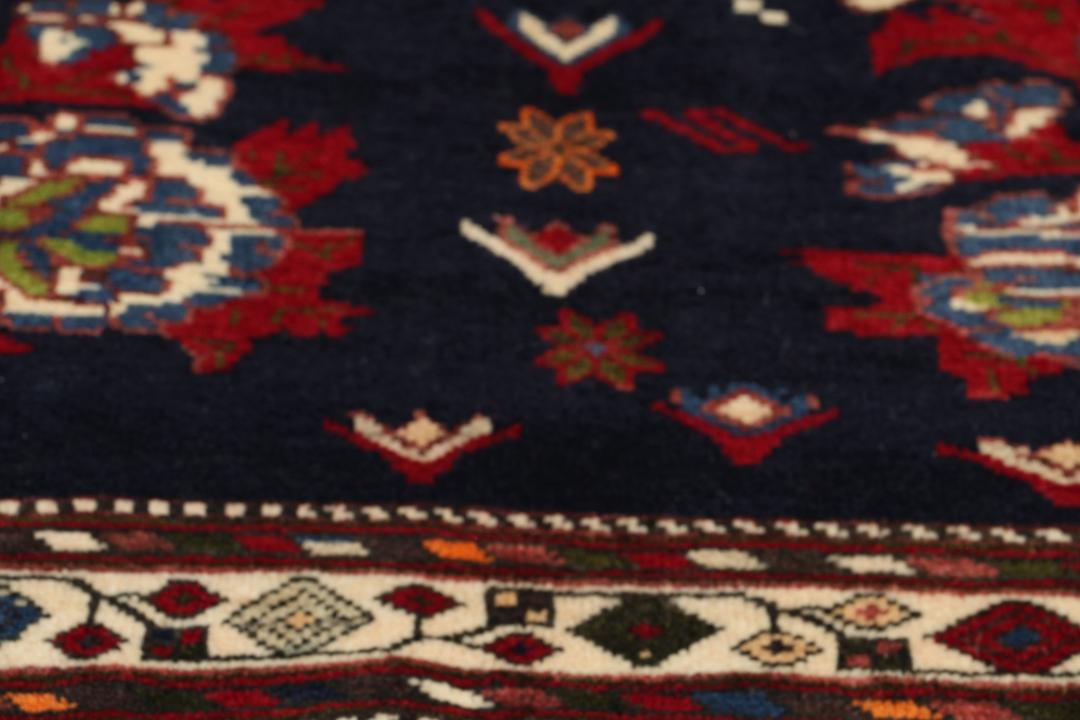 Hand-knotted Sirdjan rug from the Middle East with a dark-blue field and floral medallion pattern.