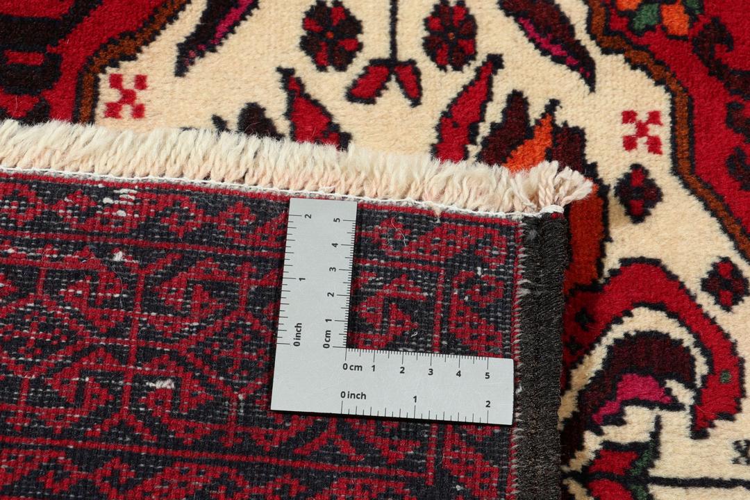 Handgeknoopt Baluch-tapijt in donkerrood met tribale medaillonmotieven uit het Midden-Oosten.