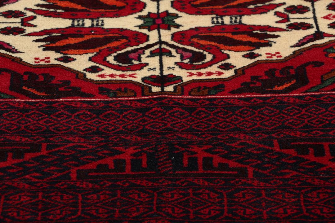 Handgeknoopt Baluch-tapijt in donkerrood met tribale medaillonmotieven uit het Midden-Oosten.