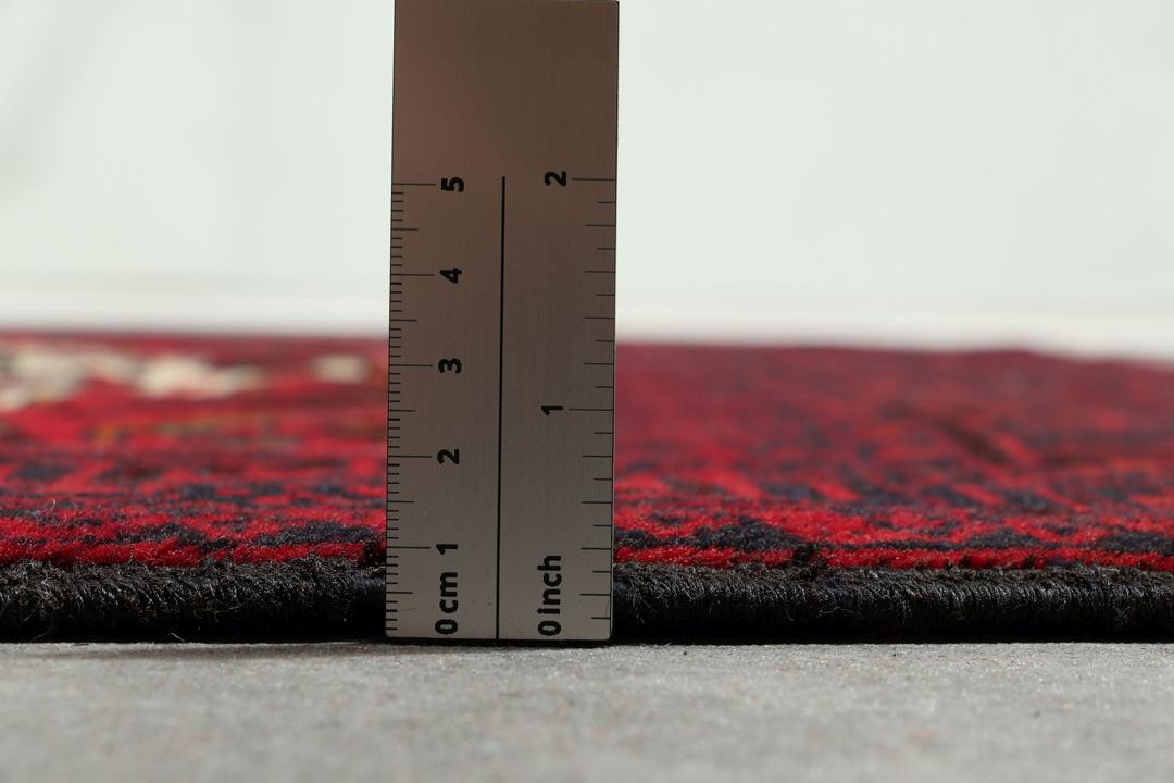 Handgeknoopt Baluch-tapijt in donkerrood met tribale medaillonmotieven uit het Midden-Oosten.