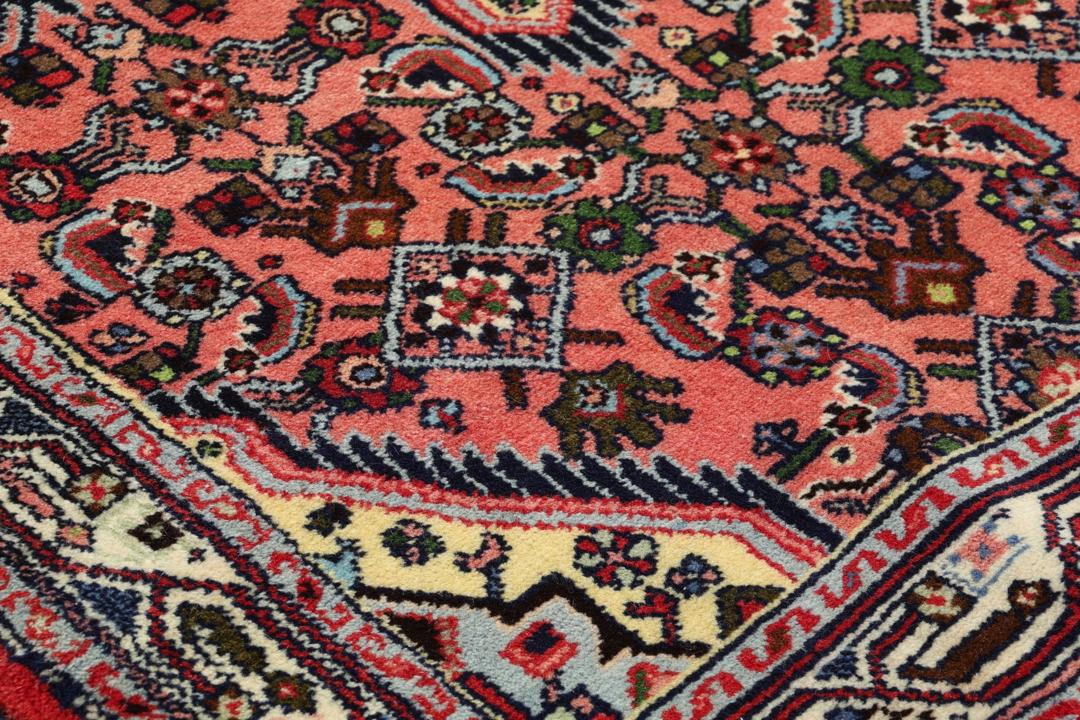 Hand knotted Asadabad rug from the Middle East in shades of red
