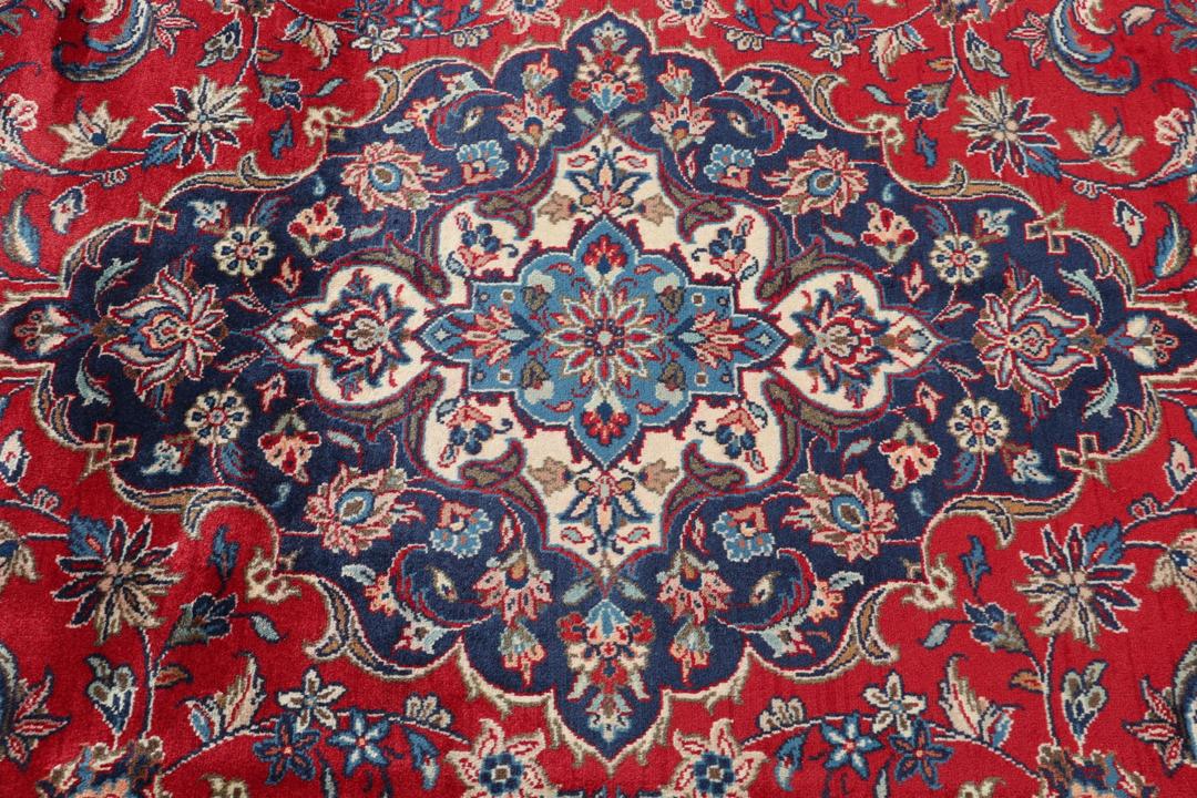 Un tapis Keshan rouge noué à la main avec un médaillon central classique et des motifs floraux.