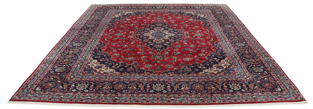 Un tapis Keshan rouge noué à la main avec un médaillon central classique et des motifs floraux.