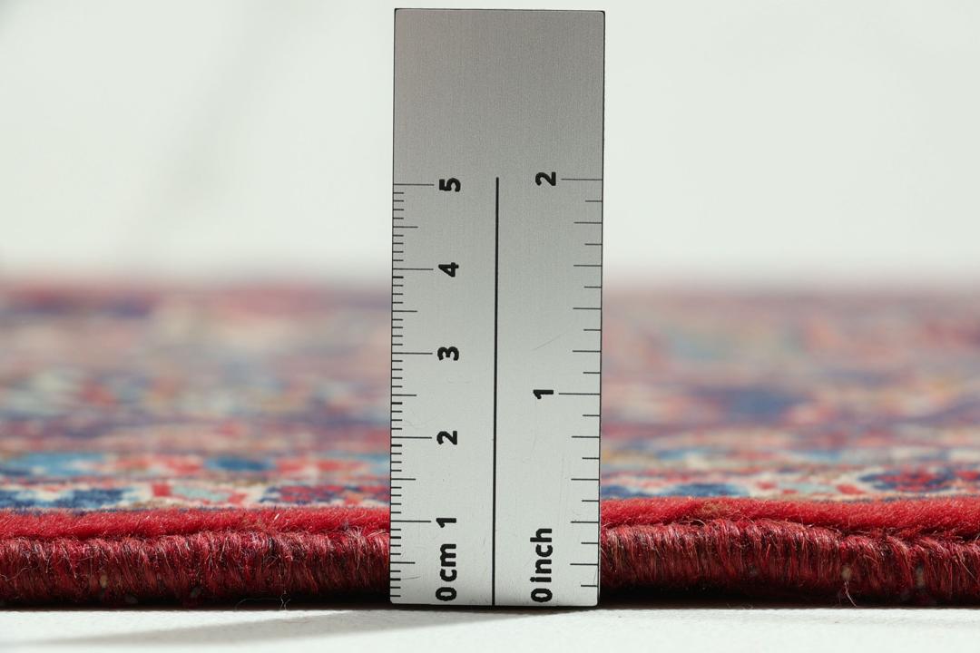 Un tapis Keshan rouge noué à la main avec un médaillon central classique et des motifs floraux.