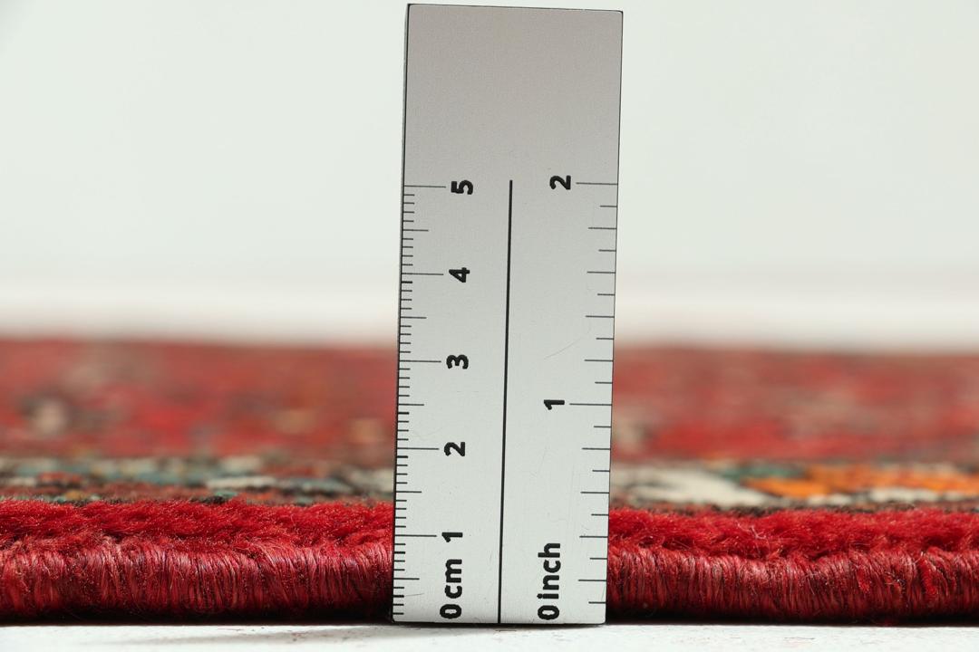 A hand-knotted Hosseinabad runner with a deep red field and geometric patterns from the Middle East.