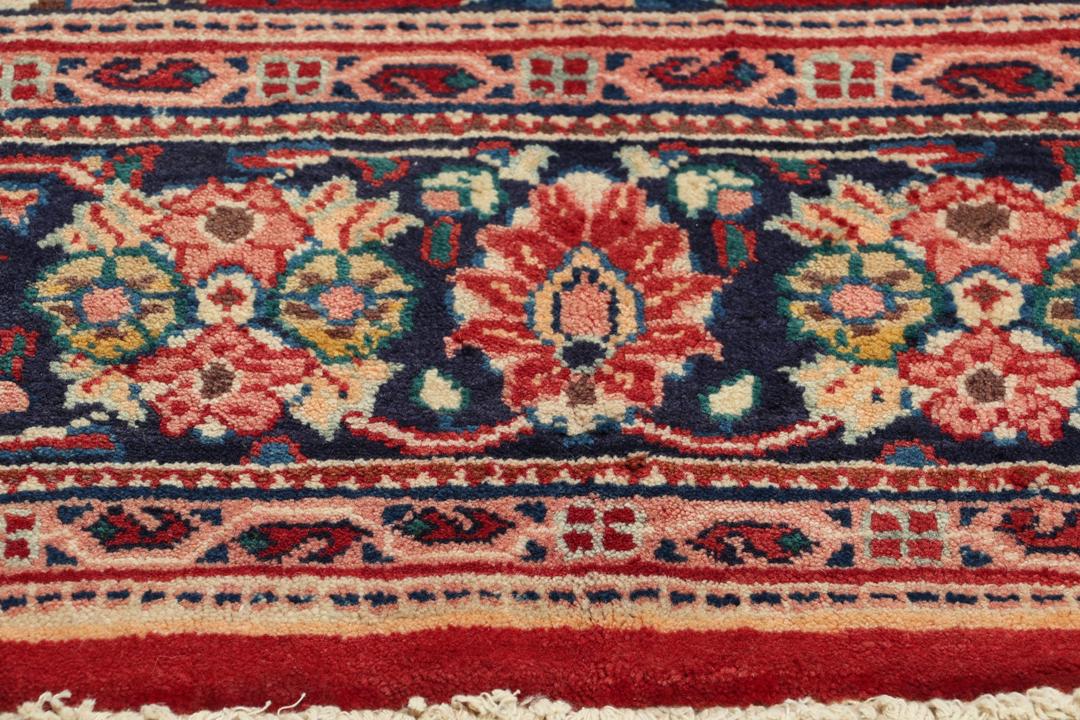 Een handgeknoopt Mahal-tapijt uit het Midden-Oosten met een donkerrood veld en sierlijke bloempatronen.