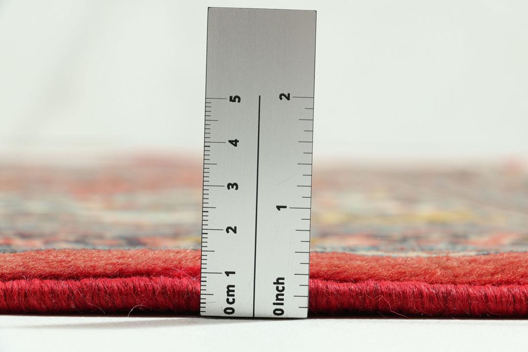 Hand-knotted Sarough rug from the Middle East with a red field and floral patterns.