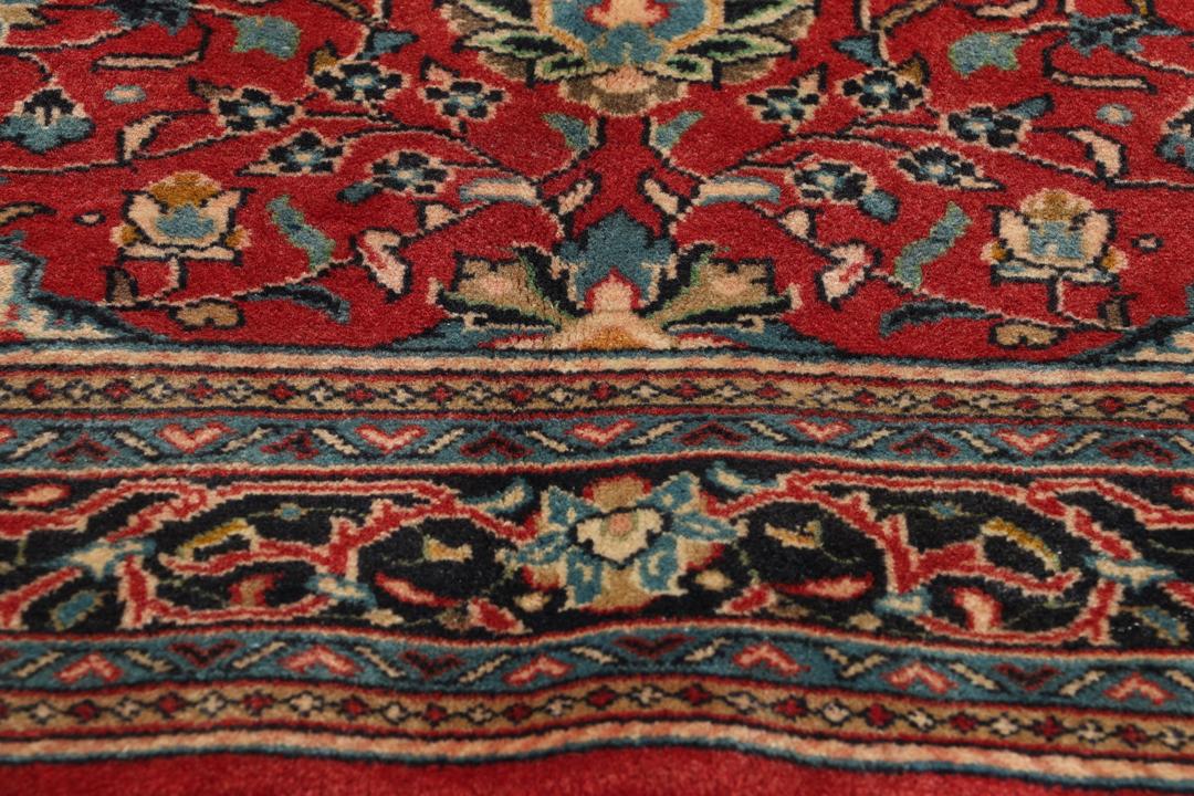Hand-knotted Sarough rug from the Middle East with a red field and floral patterns.