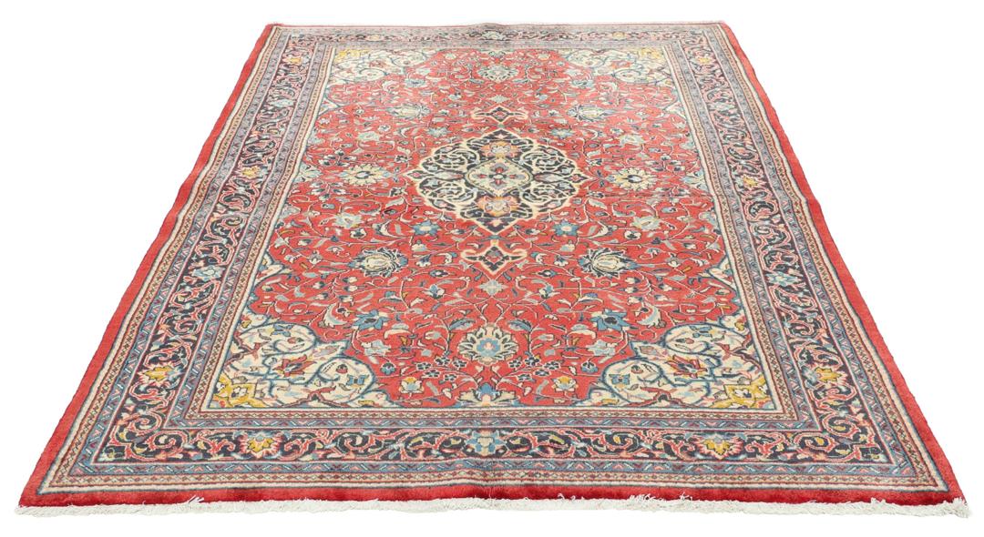 Hand-knotted Sarough rug from the Middle East with a red field and floral patterns.