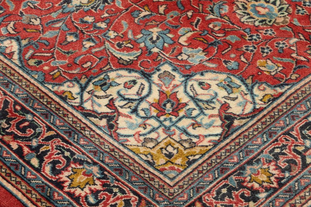 Hand-knotted Sarough rug from the Middle East with a red field and floral patterns.
