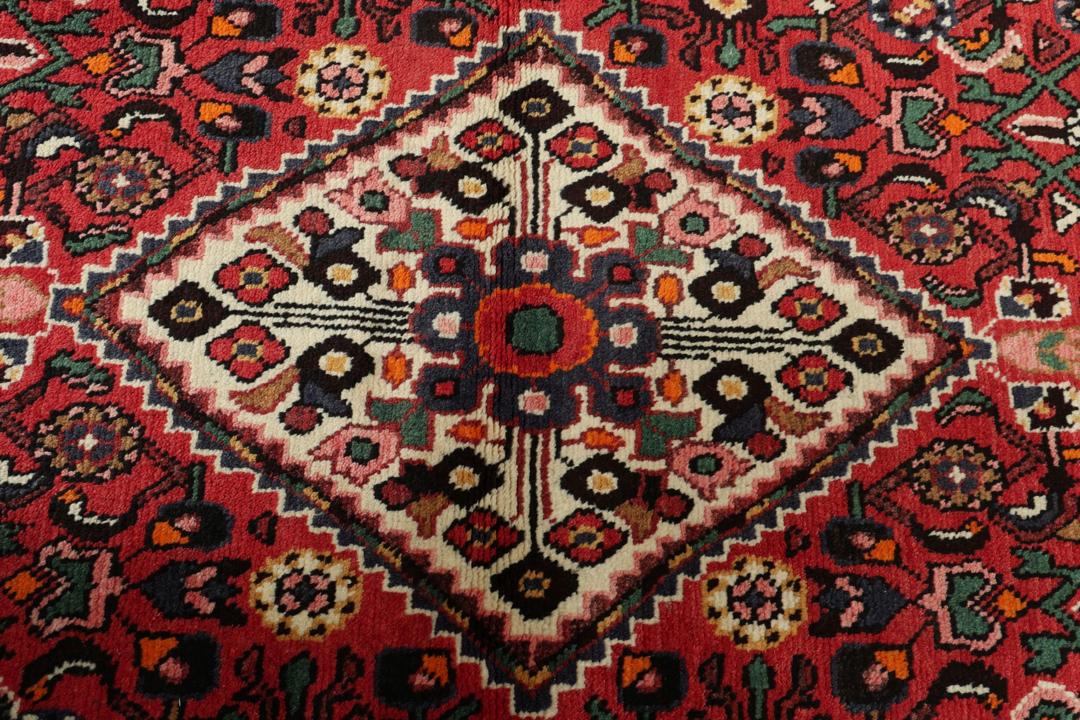 Handgeknoopte Hosseinabad loper met een levendig rood geometrisch patroon