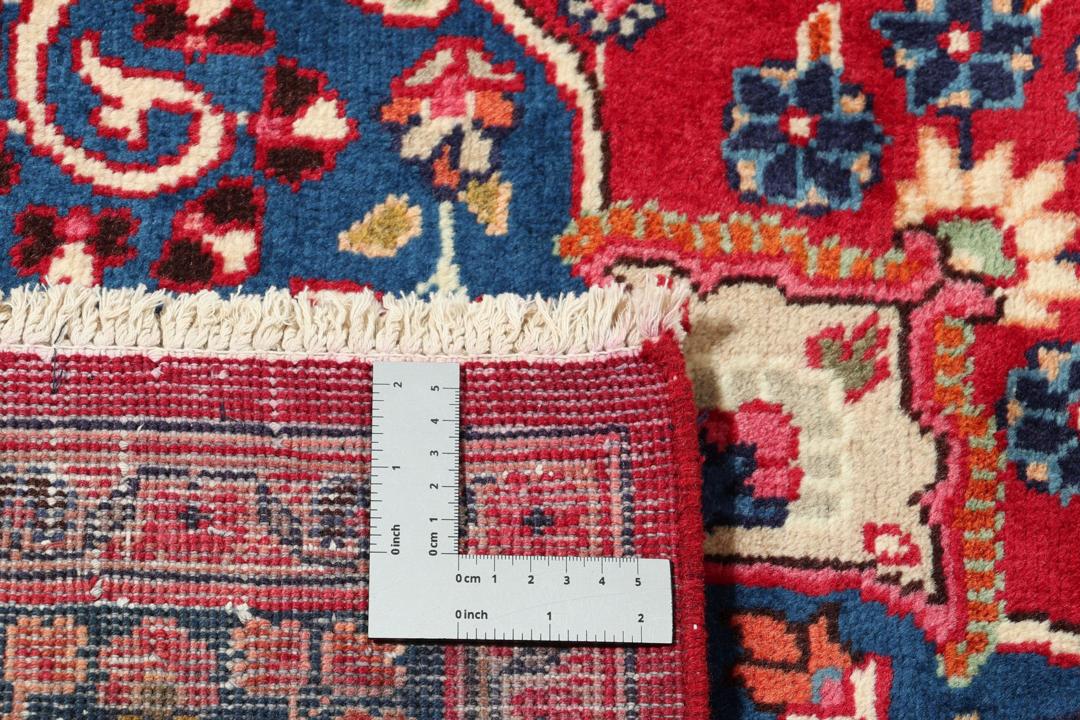 Hand-knotted Mashad rug from the Middle East with a red and blue floral pattern.