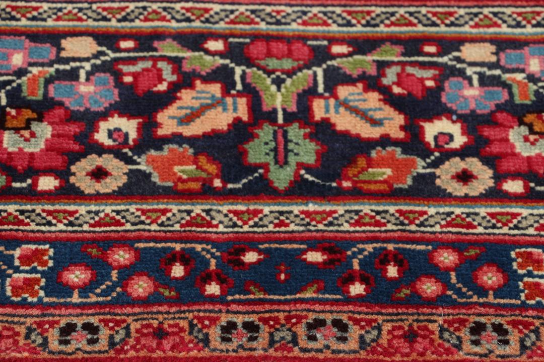 Hand-knotted Mashad rug from the Middle East with a red and blue floral pattern.