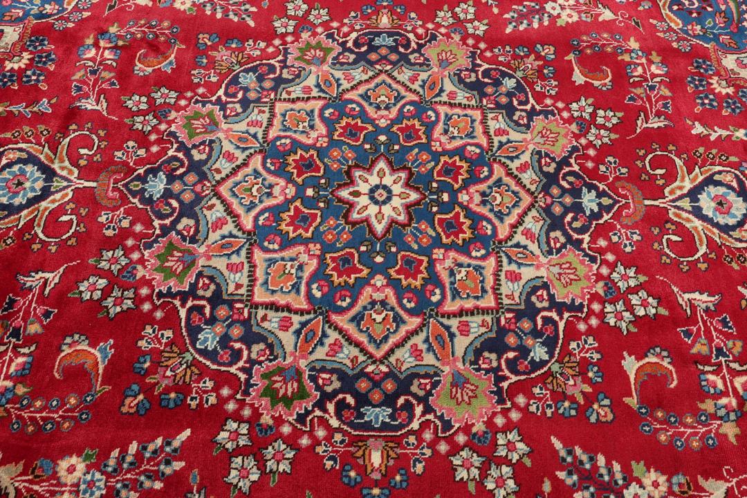 Hand-knotted Mashad rug from the Middle East with a red and blue floral pattern.