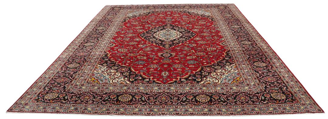 A hand-knotted Keshan rug with a red field and traditional floral medallion from the Middle East.