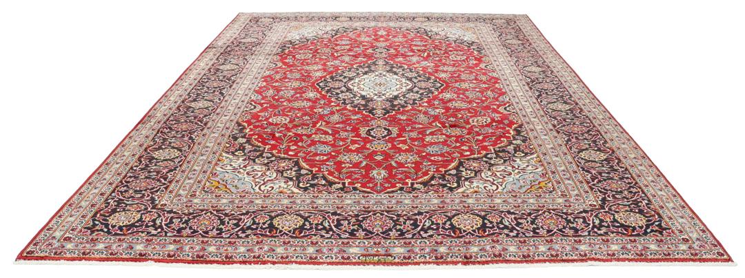 A hand-knotted Keshan rug with a red field and traditional floral medallion from the Middle East.