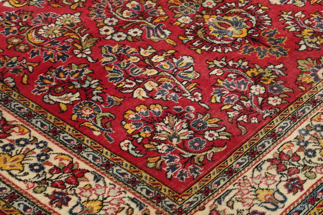A hand-knotted Sarough rug from the Middle East featuring a vibrant red field and intricate floral patterns.