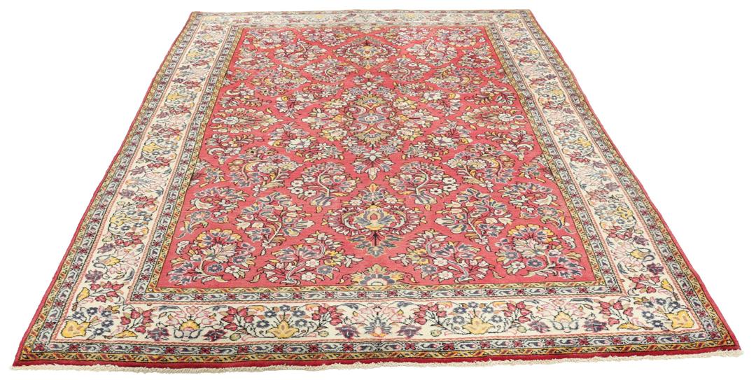 A hand-knotted Sarough rug from the Middle East featuring a vibrant red field and intricate floral patterns.