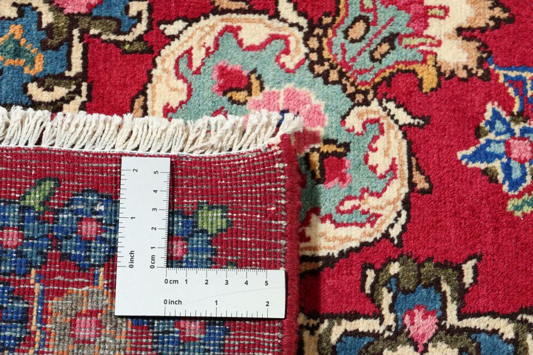 A hand-knotted Mashad rug from the Middle East in dark-red and blue tones.