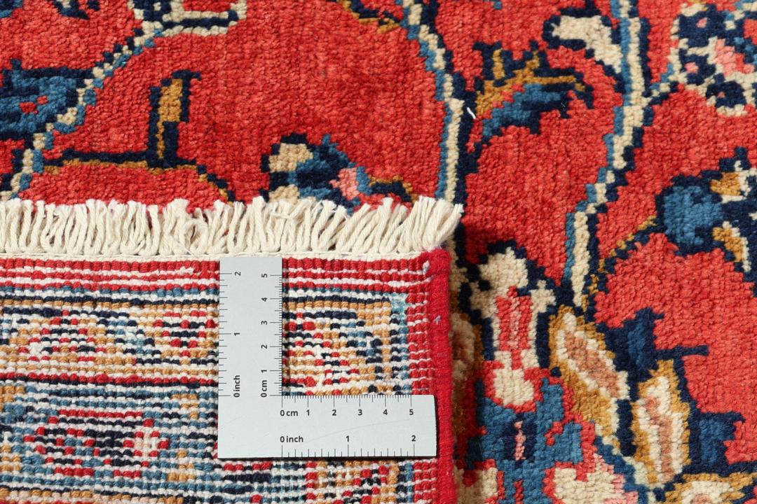 Met de hand geknoopt tapijt uit het Midden-Oosten met een centraal medaillon in rood en blauw.