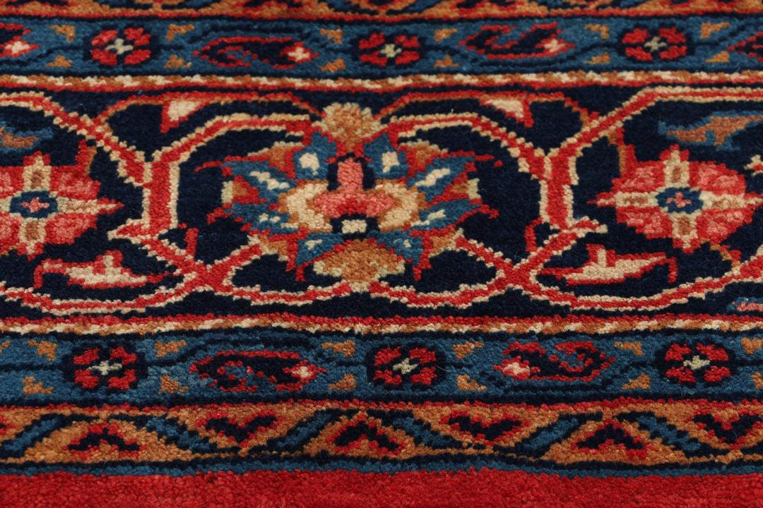 Met de hand geknoopt tapijt uit het Midden-Oosten met een centraal medaillon in rood en blauw.