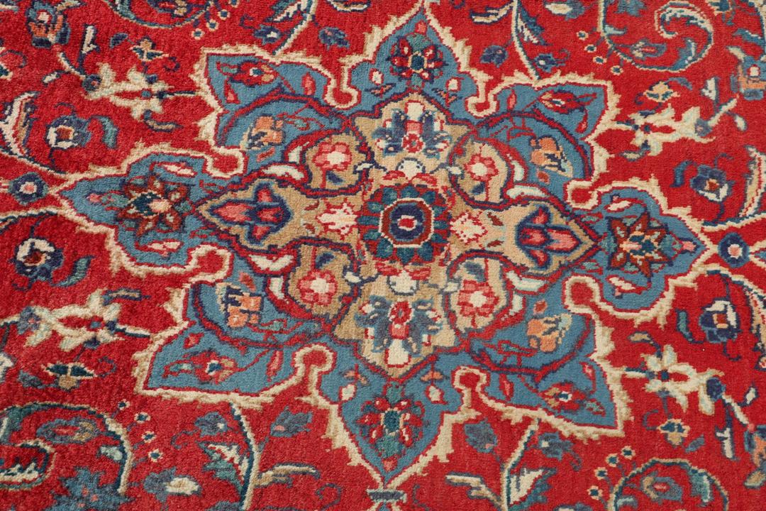 Een handgeknoopt rood Mahal-tapijt met een bloemenmedaillon en een marineblauwe rand.