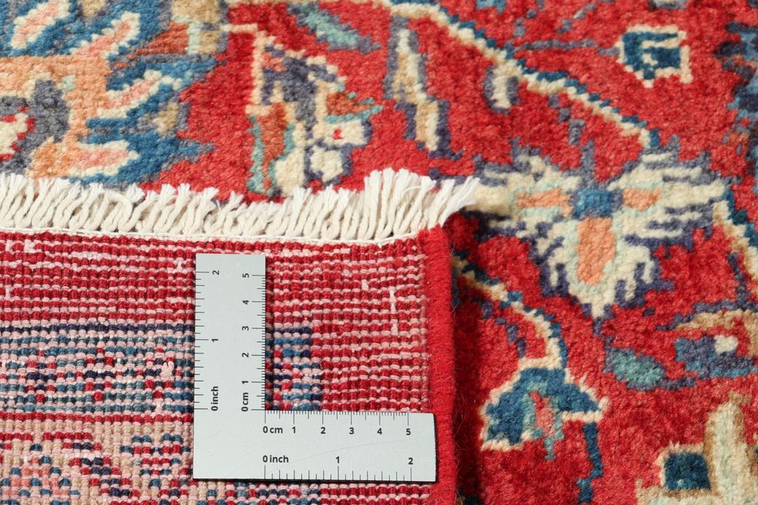 Een handgeknoopt rood Mahal-tapijt met een bloemenmedaillon en een marineblauwe rand.