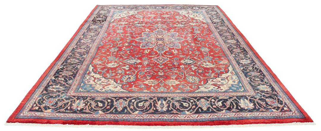 Een handgeknoopt rood Mahal-tapijt met een bloemenmedaillon en een marineblauwe rand.