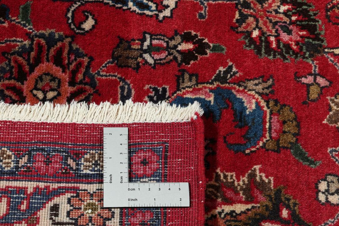 Et stort rektangulært håndknyttet Mashad-tæppe fra Mellemøsten med et dybrødt felt og blomstermønstre.