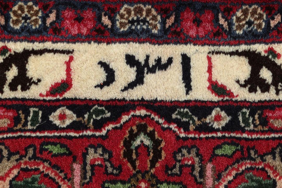 Et stort rektangulært håndknyttet Mashad-tæppe fra Mellemøsten med et dybrødt felt og blomstermønstre.