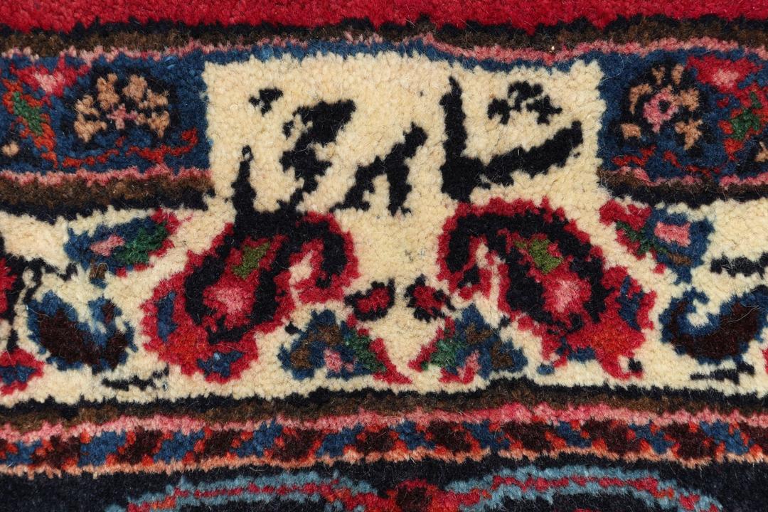 Hand-knotted Mashad rug from the Middle East in deep red and dark blue tones