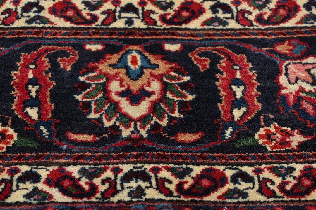 Hand-knotted Mashad rug from the Middle East in deep red and dark blue tones