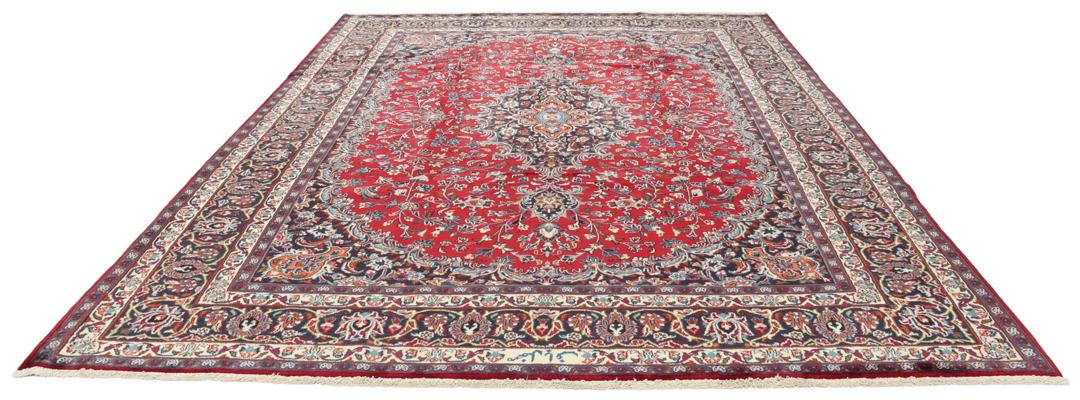 A hand-knotted Mashad rug from the Middle East in deep red and navy tones.