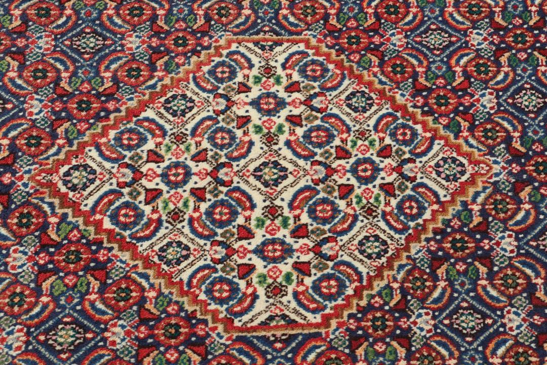 A hand-knotted Moud rug from the Middle East in dark-red and dark-blue tones.