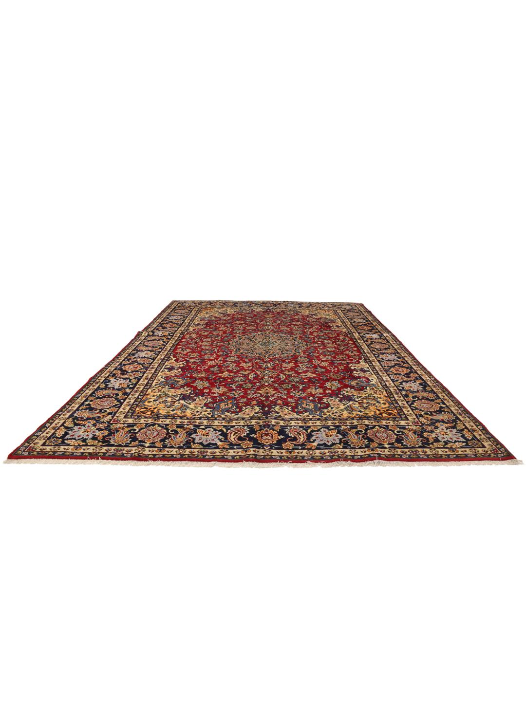 Et håndknyttet Najafabad-tæppe fra Mellemøsten med et rødt og blåt blomstermedallionmønster.