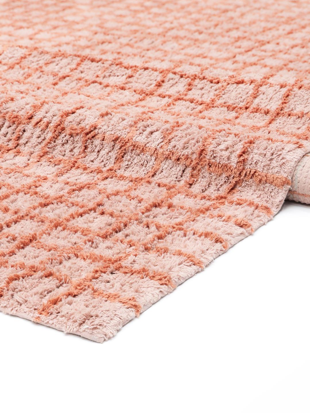 Een roze en terracotta gekleurde loper met een ruitpatroon