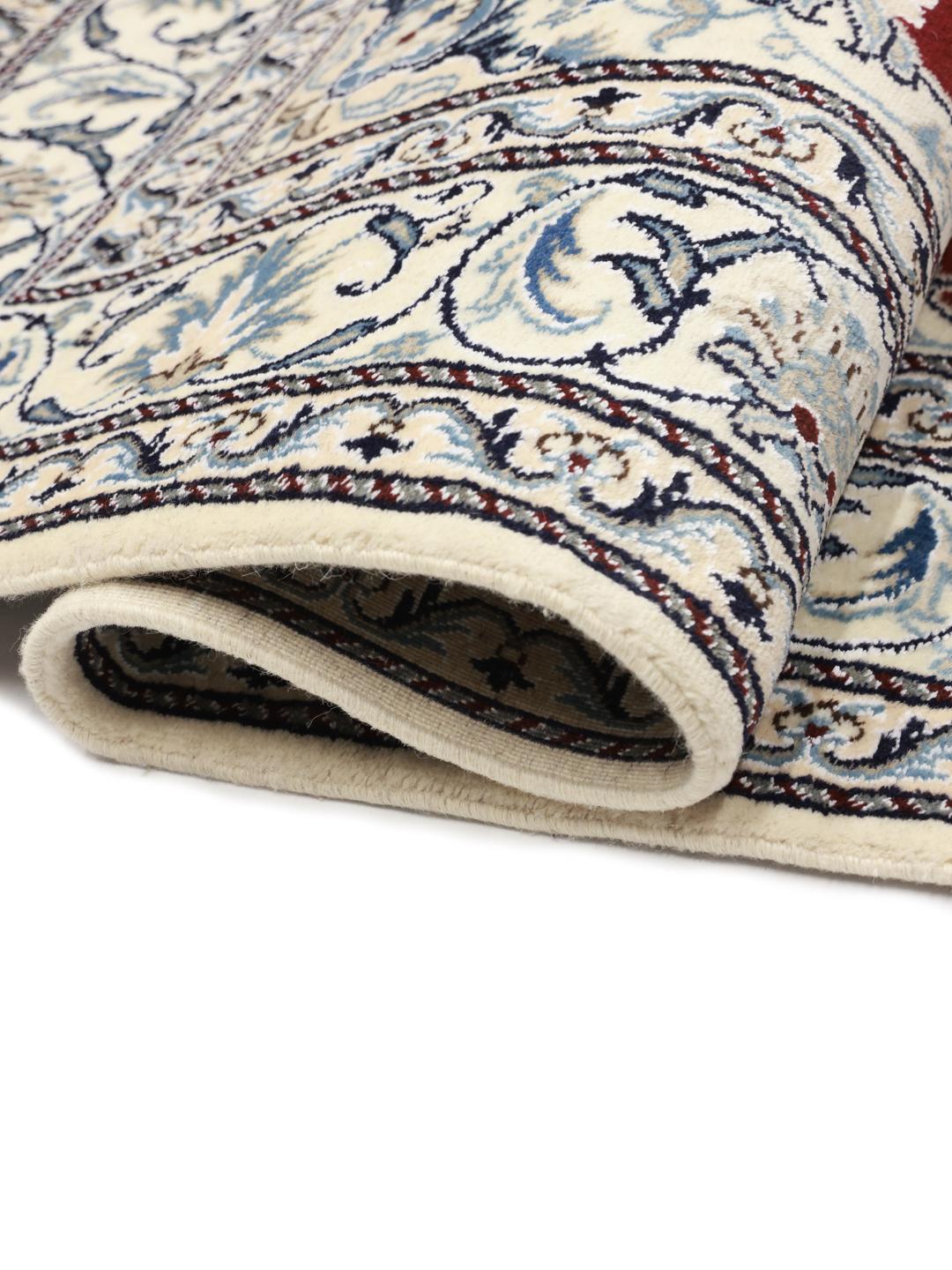 Hand-knotted Nain rug from the Middle East featuring a dark-red and blue floral medallion design.