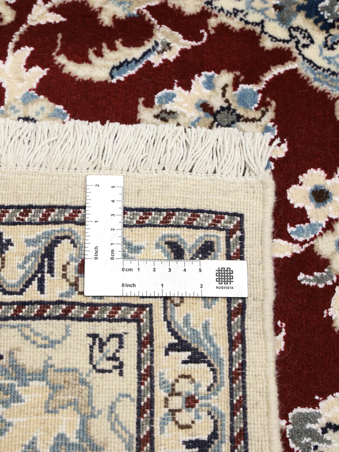 Hand-knotted Nain rug from the Middle East featuring a dark-red and blue floral medallion design.