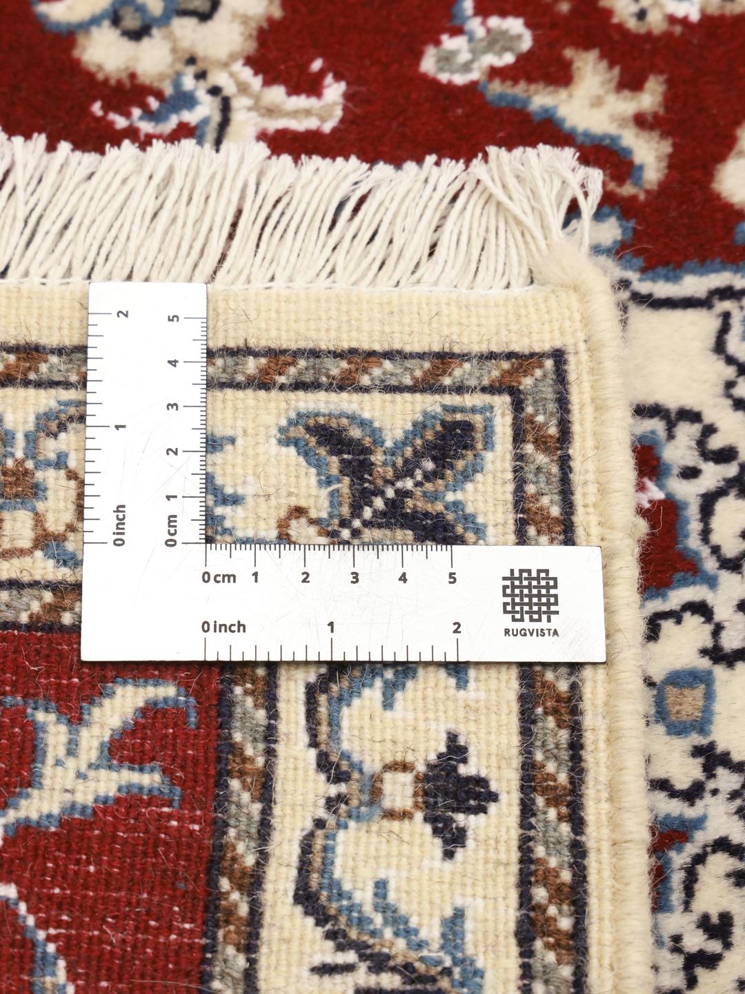 Hand-knotted Nain rug from the Middle East in dark-red with floral motifs.