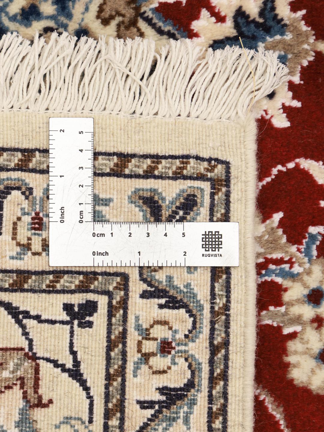 Hand-knotted Nain rug from the Middle East with a red field and floral medallion pattern.