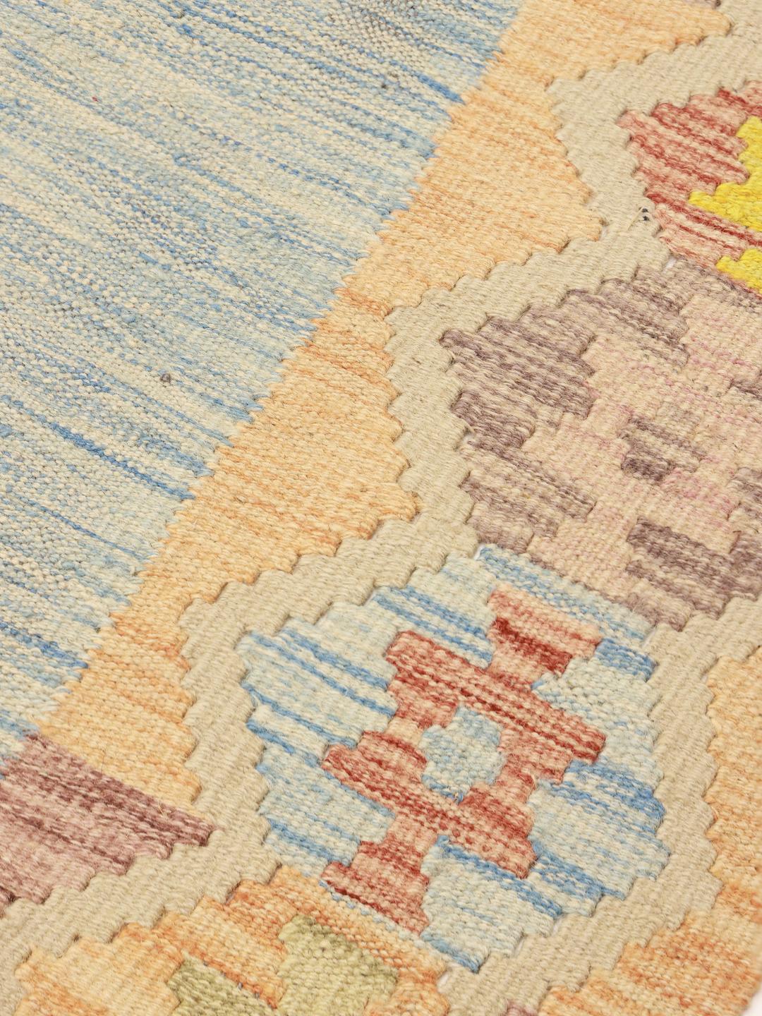 Handgeweven Afghan Kelim kleed met een centraal blauw veld en kleurrijke geometrische randen