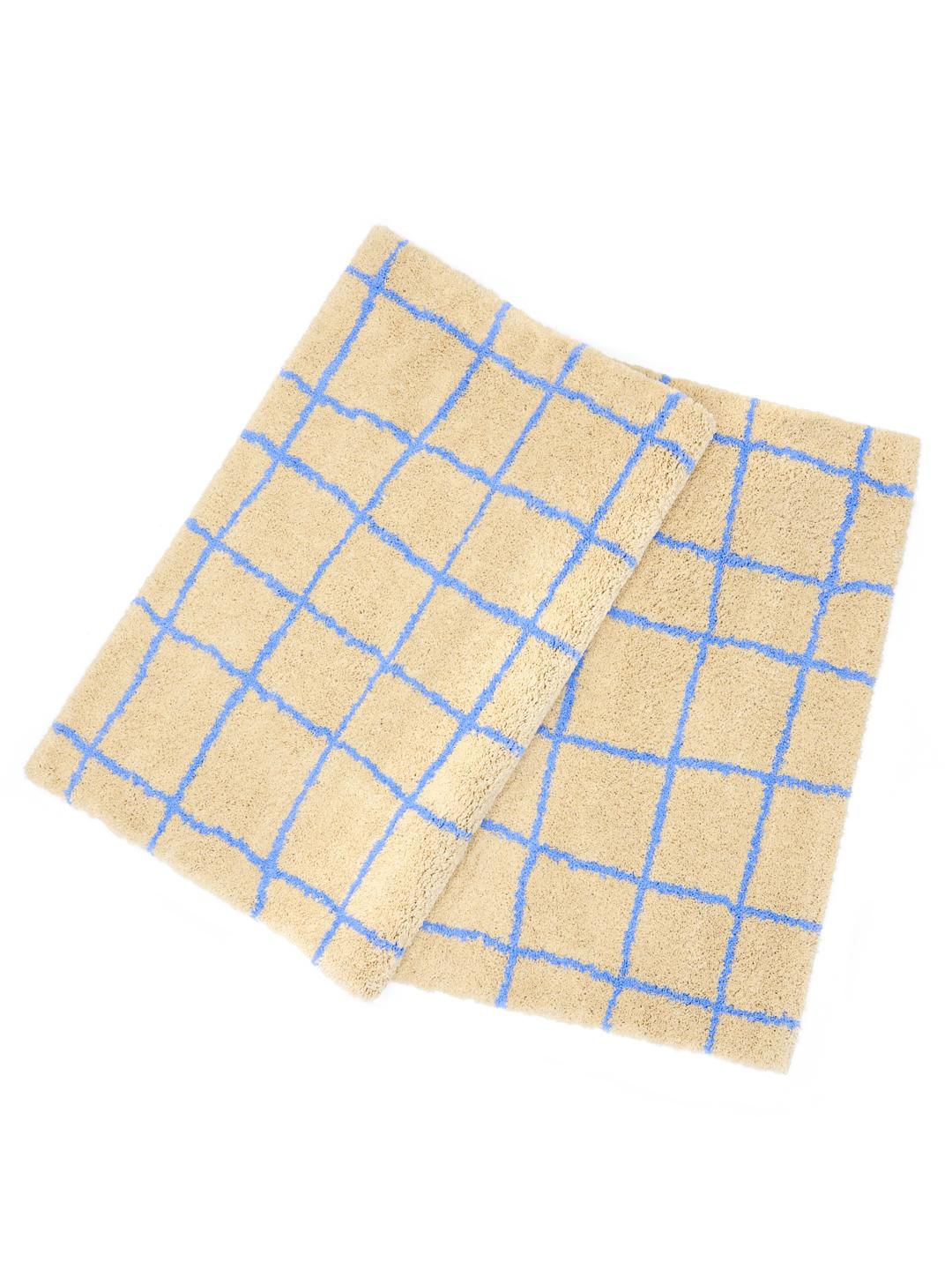 Beige en blauw vloerkleed met een ruitpatroon