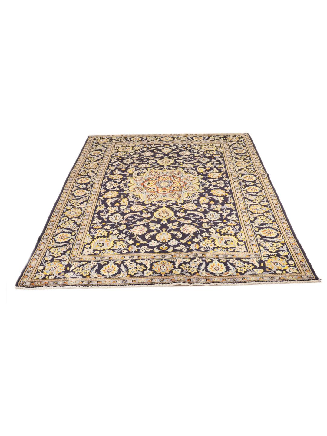 Een handgeknoopt Keshan-tapijt uit het Midden-Oosten in donkerblauw met bloemmotieven.