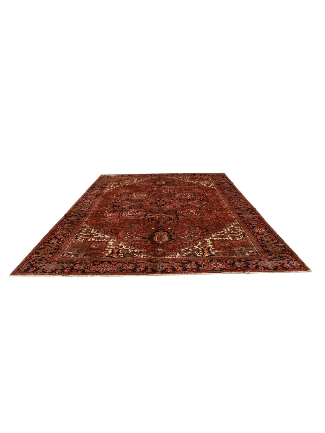 A hand-knotted Heriz rug from the Middle East with a striking red field and intricate geometric medallion.