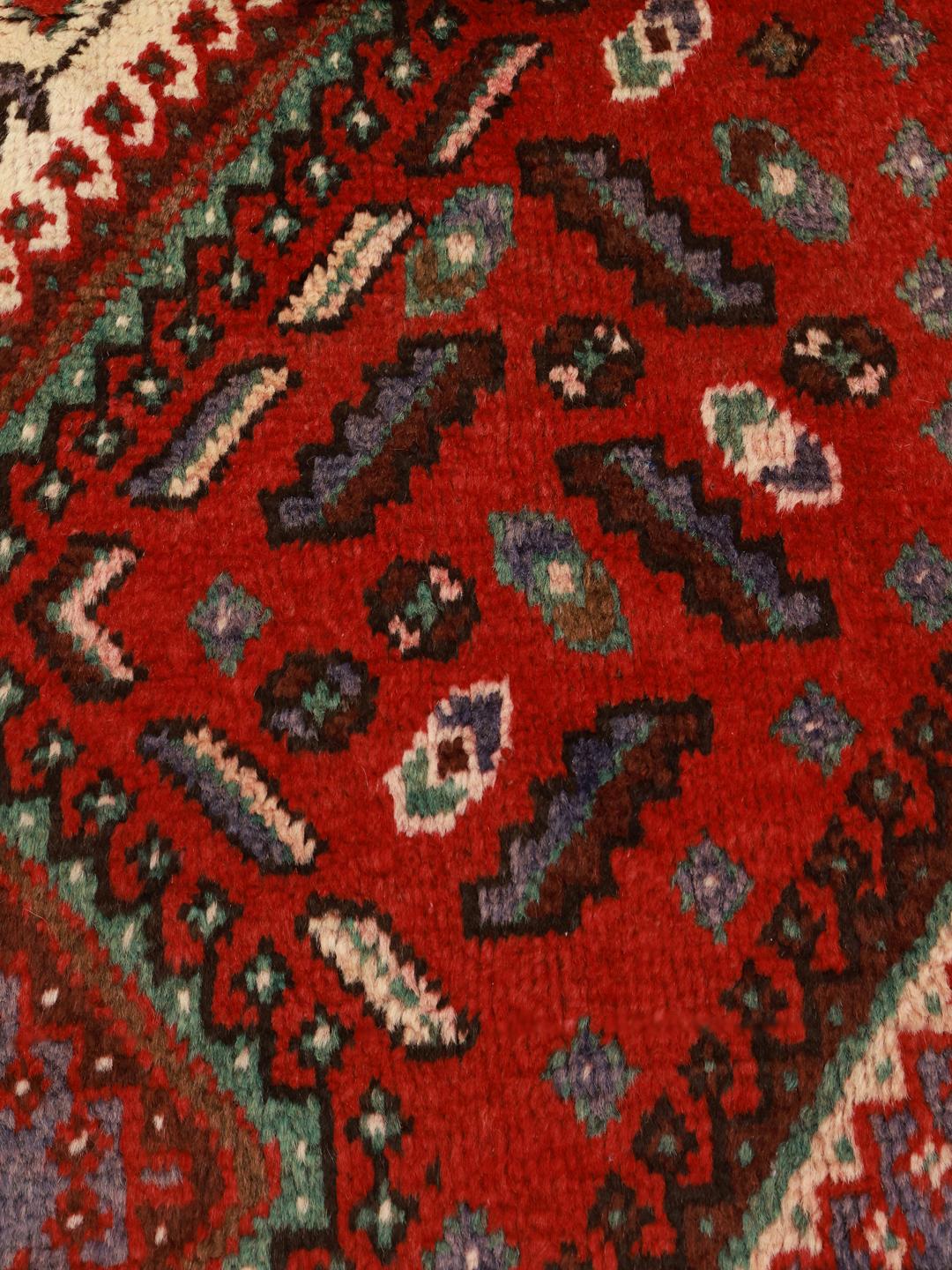 Een handgeknoopt Joshaghan-tapijt uit het Midden-Oosten in tinten rood en blauw.
