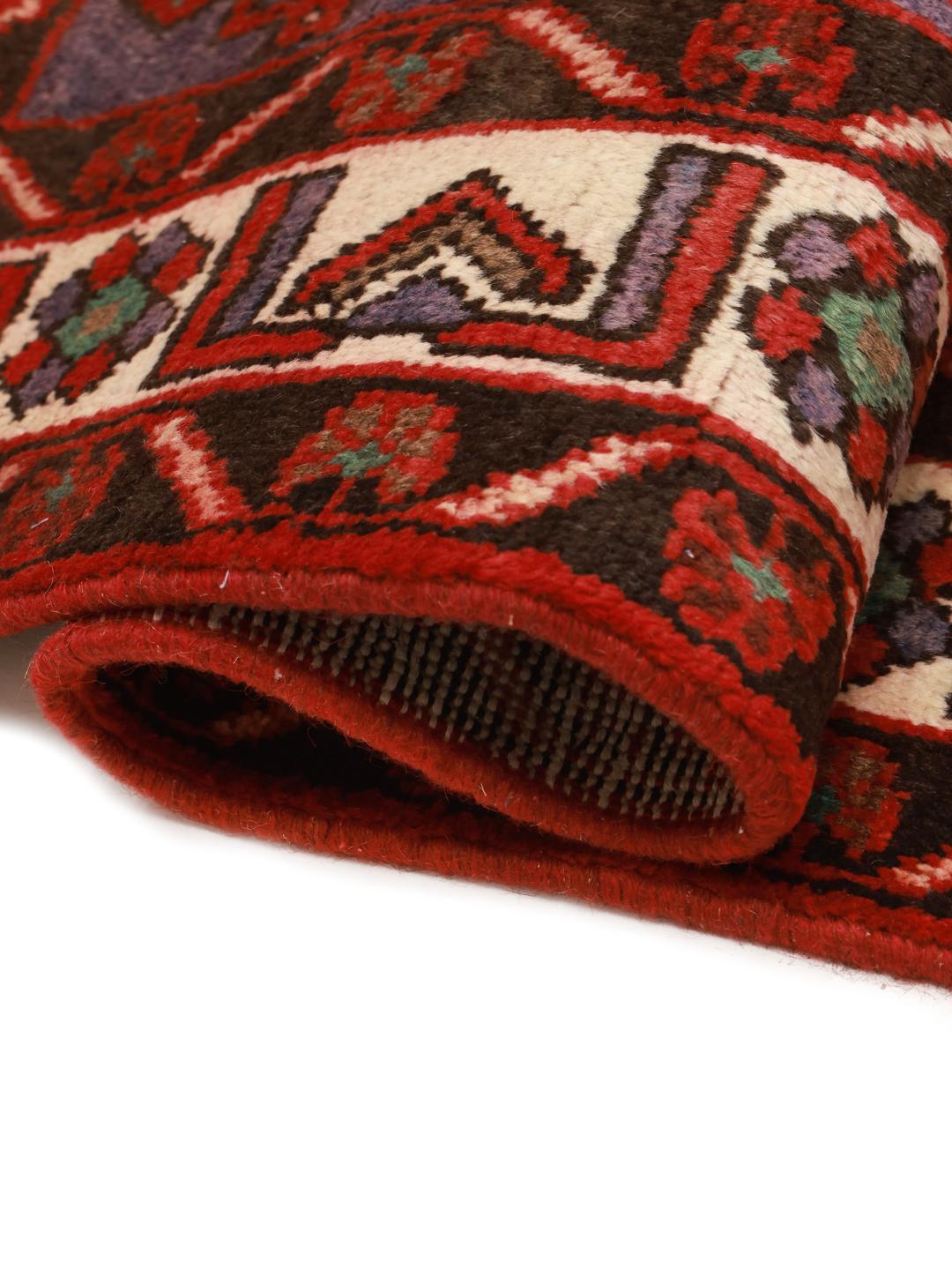 Een handgeknoopt Joshaghan-tapijt uit het Midden-Oosten in tinten rood en blauw.